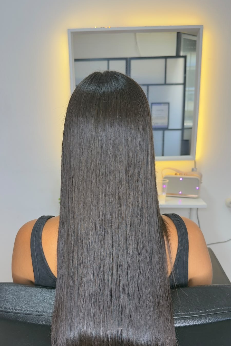 The same dark hair after the Fibroseal treatment, smooth and reflective