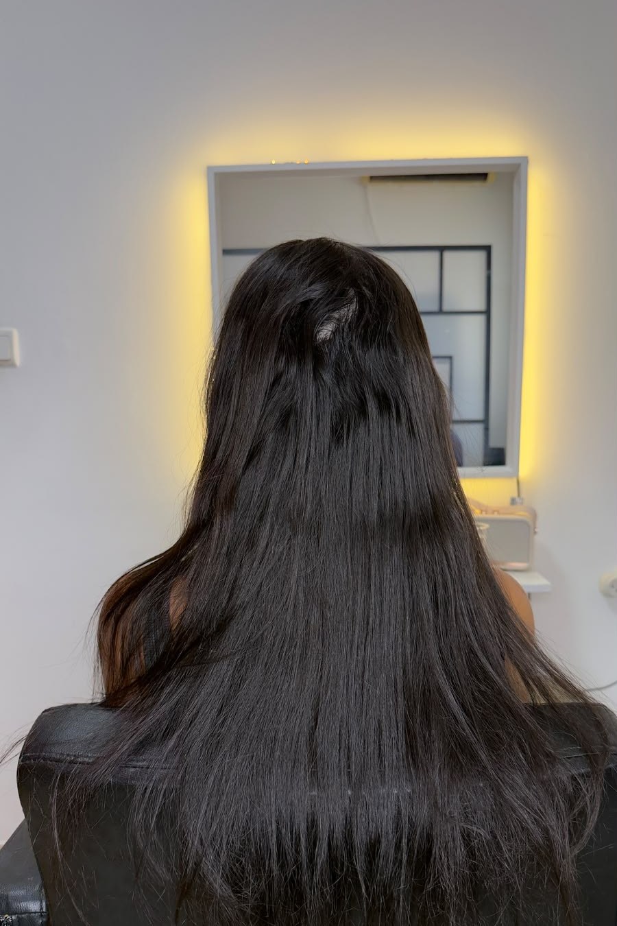 Long dark hair before the Fibroseal treatment, showing frizz and texture